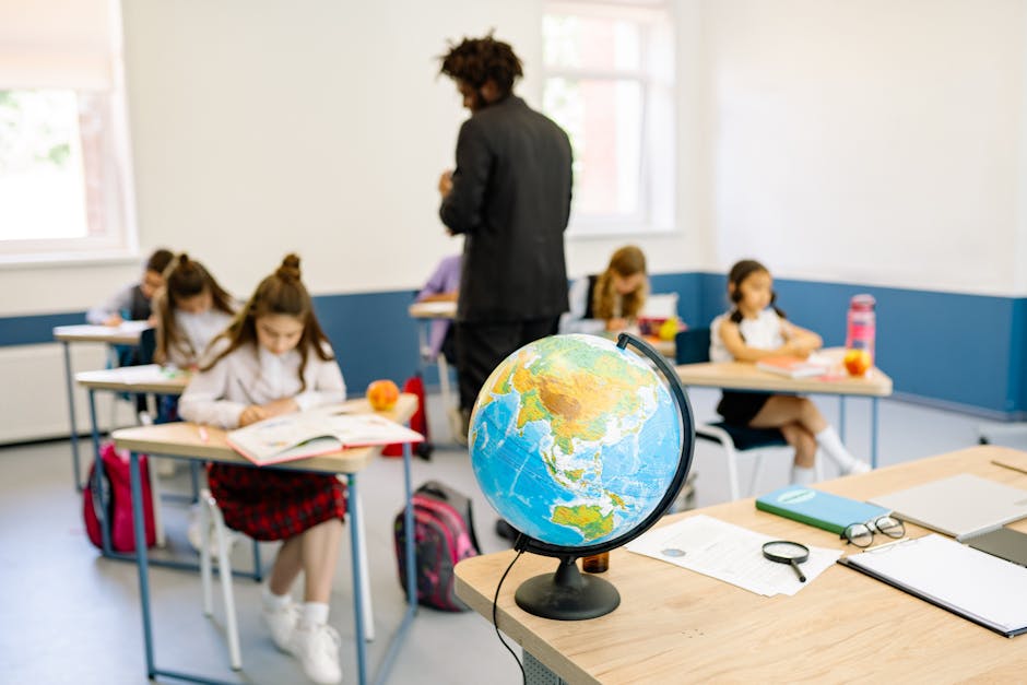 A classroom scene with students studying geography, highlighted by a prominent globe on the teacher's desk